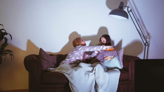 Filles avec du popcorn ayant une soirée de cinéma