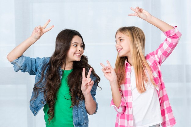 Filles espiègles montrant le signe de la paix