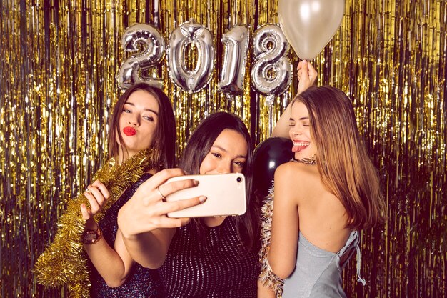 Filles heureux prenant selfie sur la célébration du nouvel an
