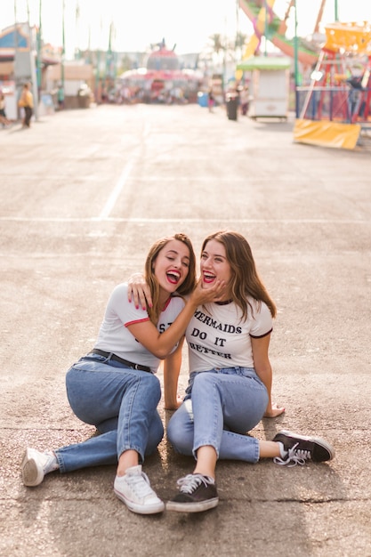 Filles heureux s&#39;amuser dans le parc d&#39;attractions