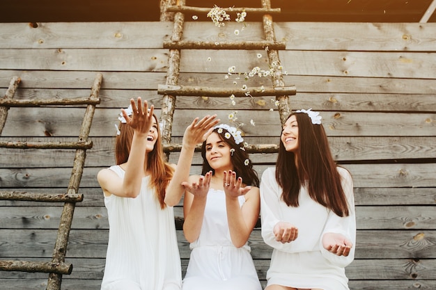 Photo gratuite les filles jetant des fleurs dans l'air