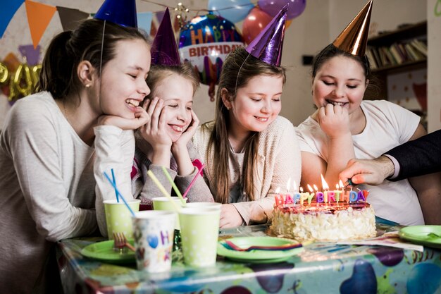 Filles joyeuses en regardant les bougies d&#39;éclairage de la main