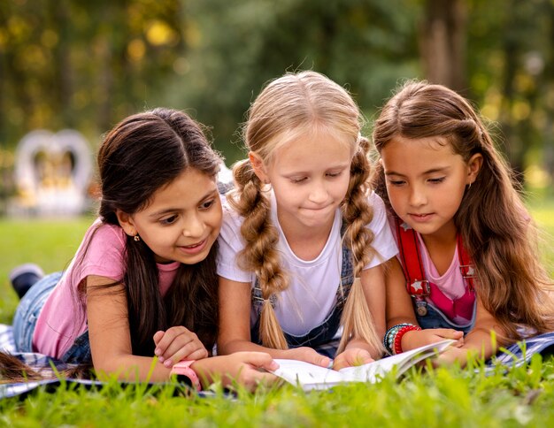 Filles lisant un livre sur l'herbe