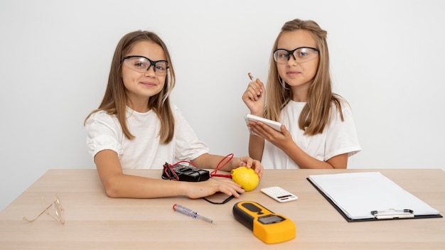 Filles avec des lunettes de sécurité faisant des expériences scientifiques