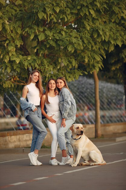 Filles marchant dans une ville de printemps avec un chien mignon