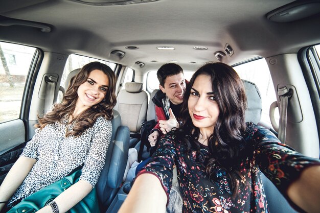 Filles et mec prenant selfie en voiture