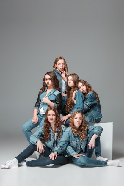 filles de la mode debout ensemble et regardant la caméra sur studio gris