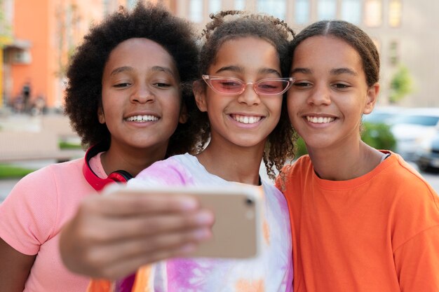 Filles à plan moyen prenant un selfie