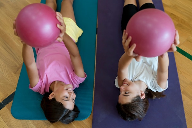 Filles de plan moyen sur des tapis de yoga