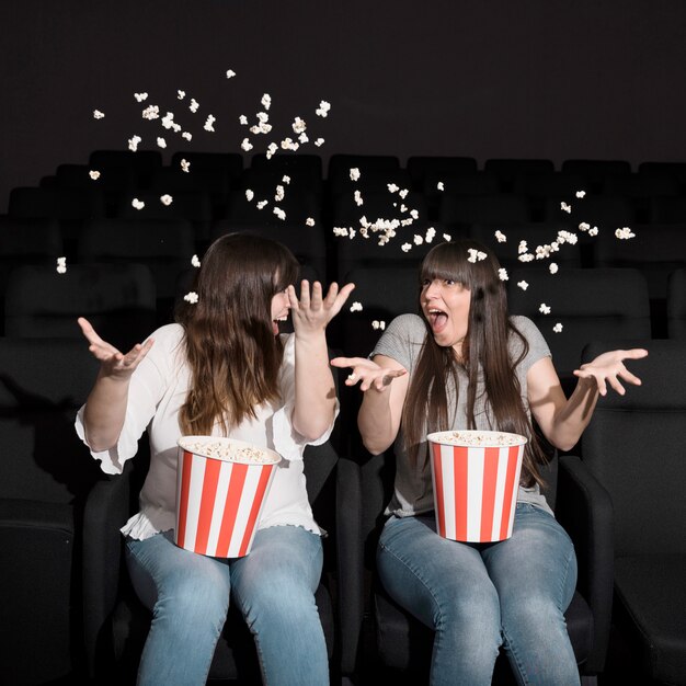 Filles avec pop-corn au cinéma