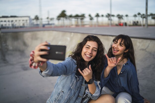 Filles prenant une photo d'elles-mêmes dans un skate park