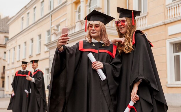 Filles prenant selfie à l'obtention du diplôme