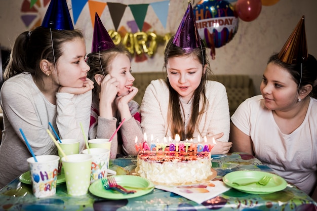 Filles regardant un gâteau avec des bougies