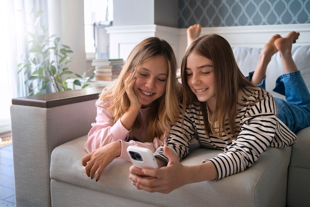 Photo gratuite filles souriantes à coup moyen avec des appareils