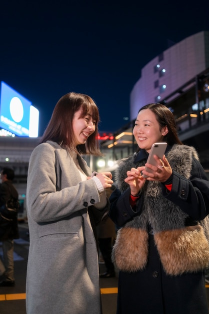 Filles souriantes à coup moyen avec smartphone