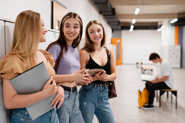 Filles souriantes à plan moyen à l'école