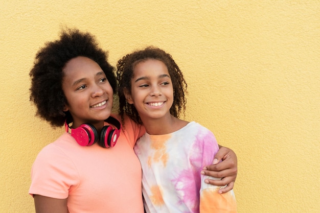 Photo gratuite filles souriantes à plan moyen s'embrassant