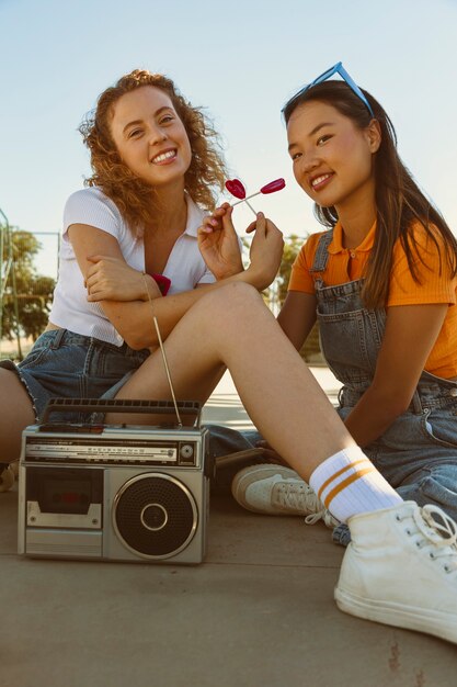 Filles souriantes pleines avec lecteur de cassettes