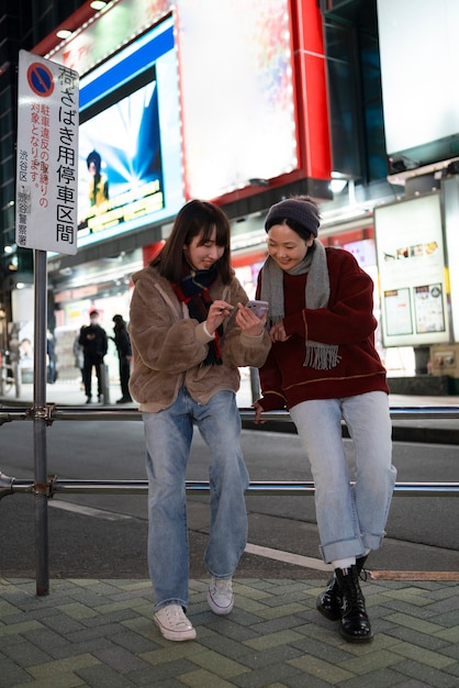 Filles souriantes pleines avec smartphone