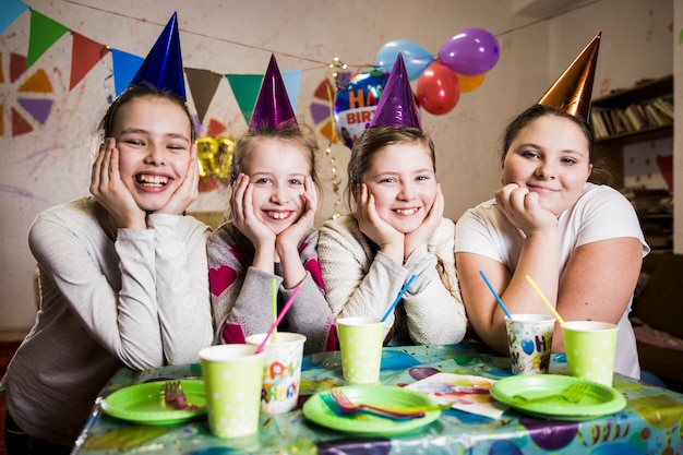 Filles souriantes à table sur la fête d&#39;anniversaire