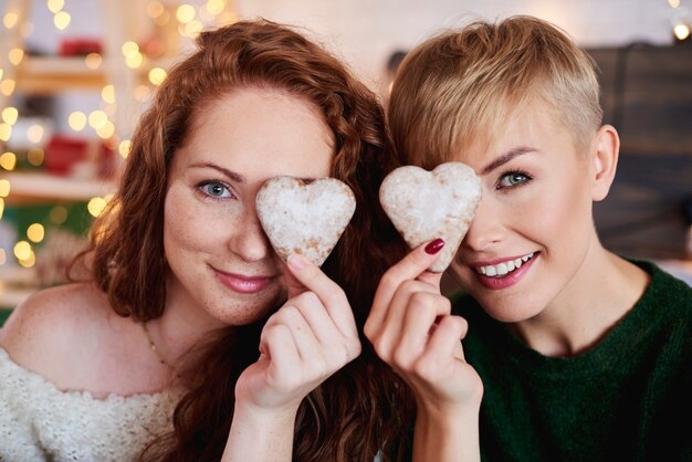 Filles souriantes tenant des biscuits de pain d'épice en forme de coeur