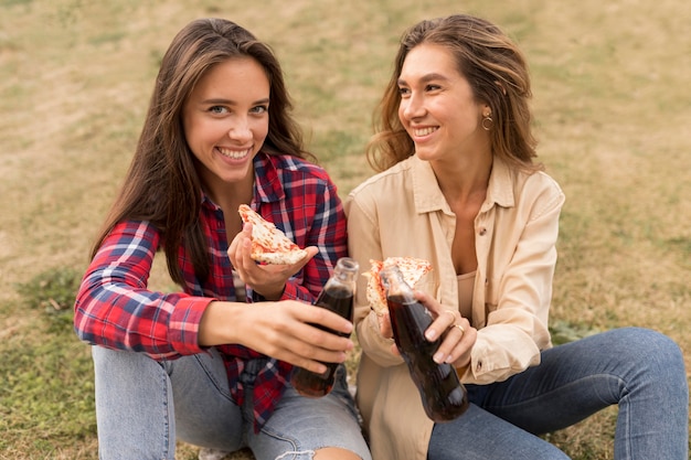 Filles de tir moyen avec pizza et soda