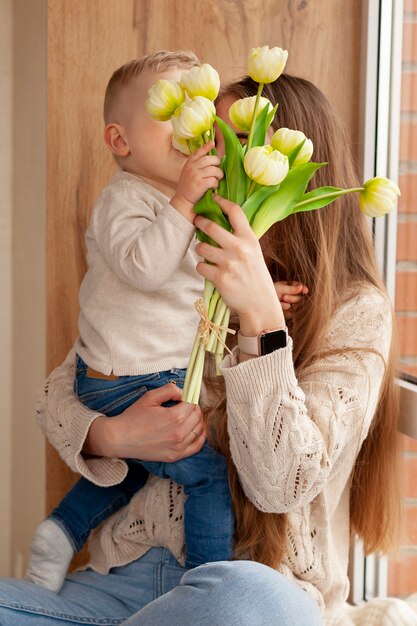 Fils donnant des fleurs à maman