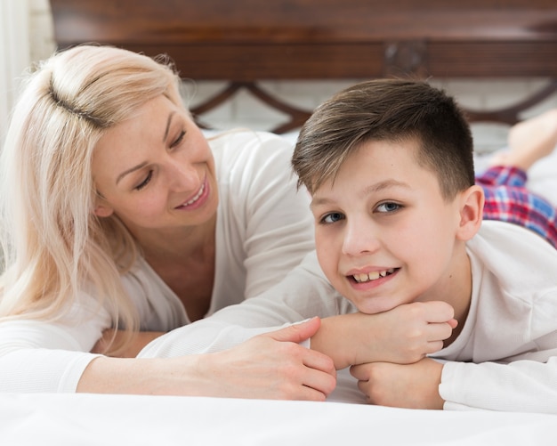 Photo gratuite fils et mère au grand angle au lit