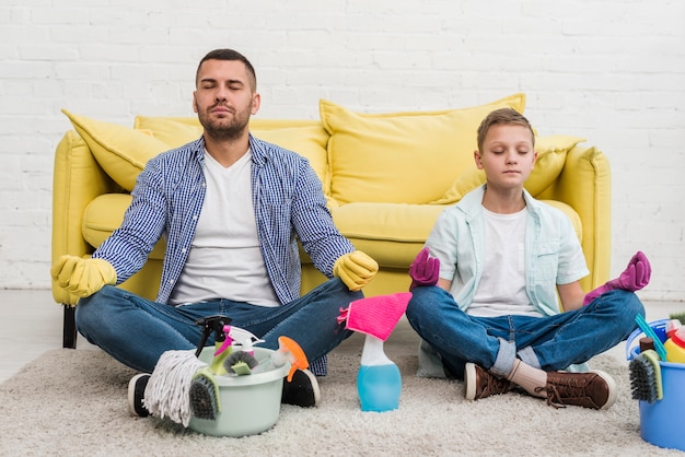 Fils et père faisant du yoga après le nettoyage