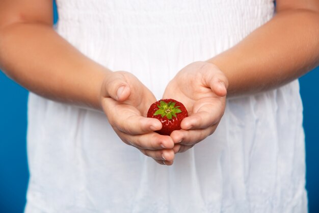 Fin, haut, girl, main, tenue, fraise, bleu, mur