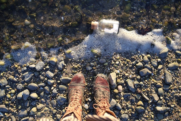 Photo gratuite fiole sur le rivage et vue de dessus des bottes