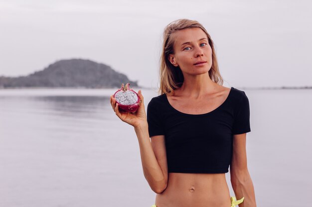 Fit bronzé jeune femme caucasienne en mer au coucher du soleil