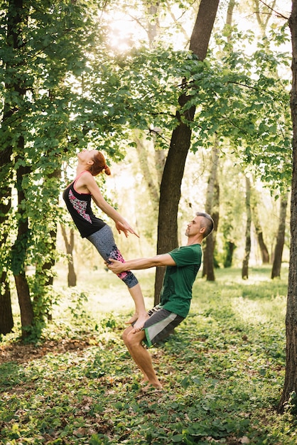 Fit couple faisant acroyoga équilibre dans le parc