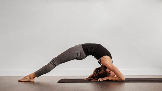 Fit femme faisant du yoga à la maison