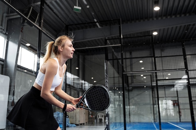 Photo gratuite fit femme jouant au paddle-tennis vue latérale