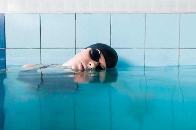 Fit femme relaxante dans la piscine