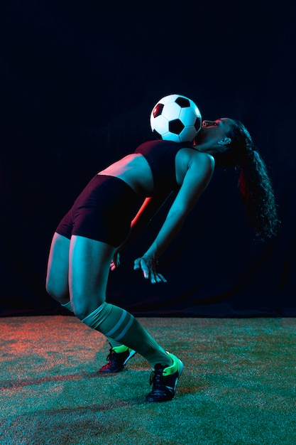 Fit jeune femme jouant au football