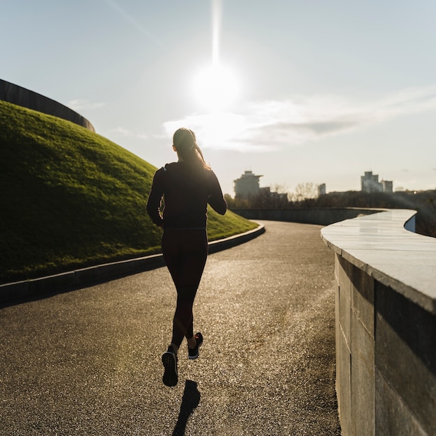 Photo gratuite fit la jeune femme qui court dans le parc