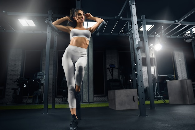 Fitnesswoman posant dans la salle de gym.