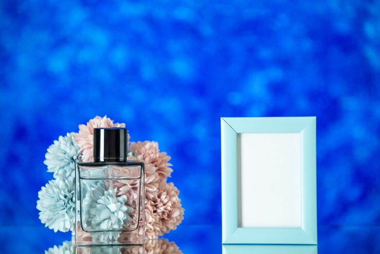 Photo gratuit flacon de parfum vue de face petit cadre photo bleu fleurs sur fond bleu espace libre