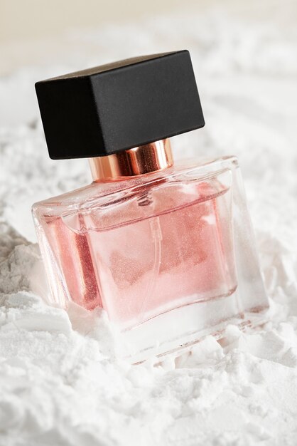 Flacon en verre de parfum féminin sur poudre texturée