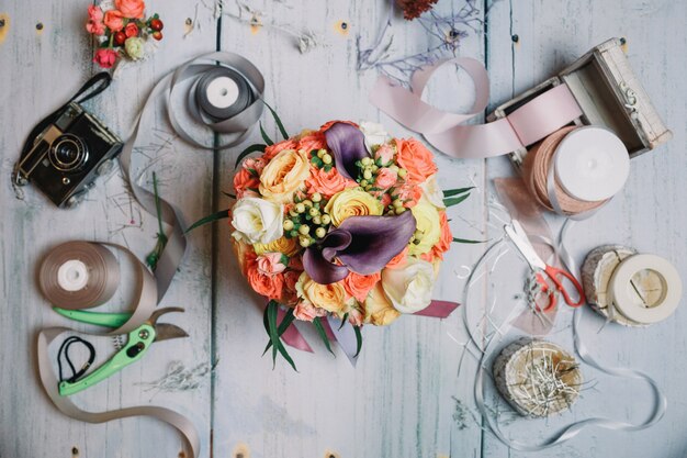 Flatlay de bouquet de mariage, rubans et caméra