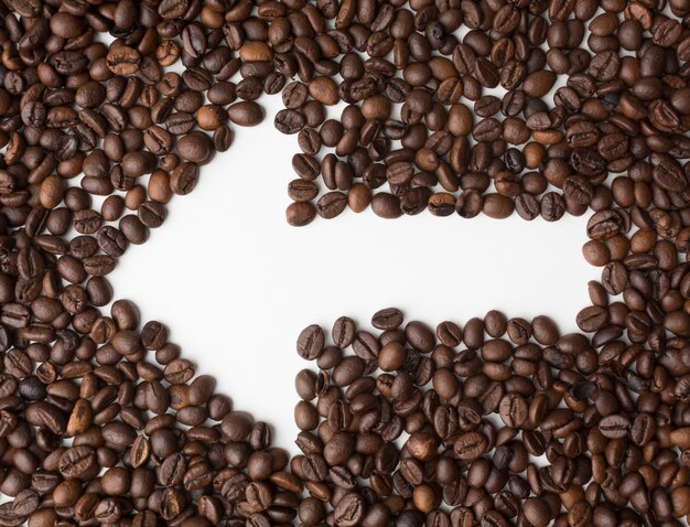 Flèche à travers les grains de café pointant vers la gauche