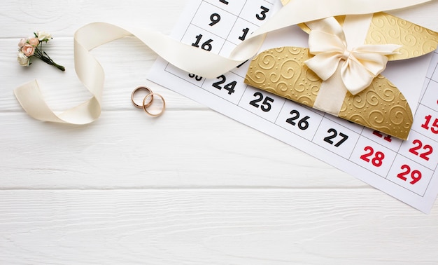 Photo gratuite fleur et anneaux de mariage avec calendrier