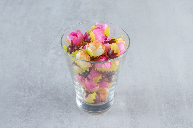 Fleur colorée et verre, sur le tableau blanc.