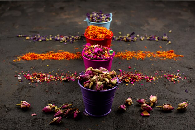 Fleur de feuilles multicolores et autres particules colorées en pots sur un bureau gris