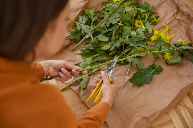 Fleuriste coupant des parties de fleurs