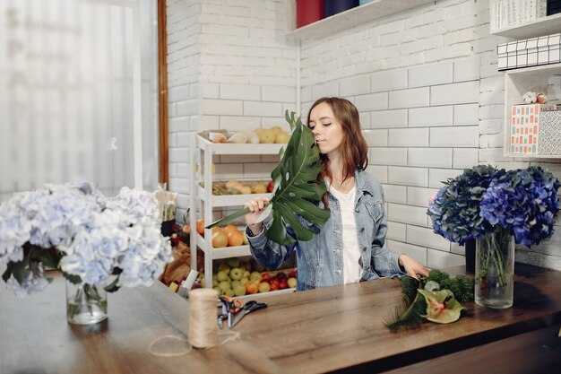 Fleuriste dans un magasin de fleurs faisant un bouquet