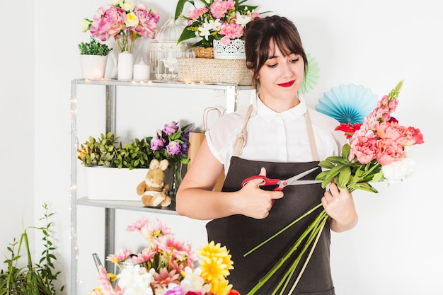 Fleuriste femme coupe des tiges de fleurs avec des ciseaux