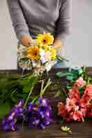 Photo gratuite fleuriste femme faire un bouquet de fleurs colorées